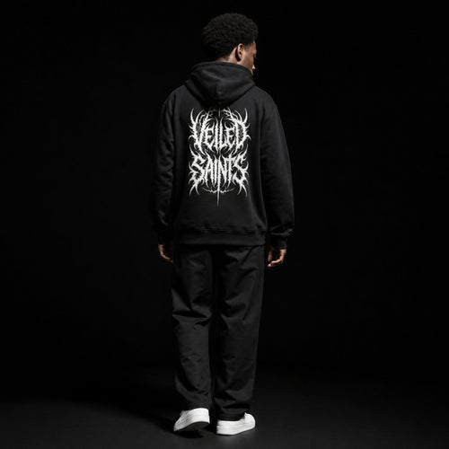 Back of a black organic cotton hoodie with the Veiled Saints wordmark in thorned gothic script